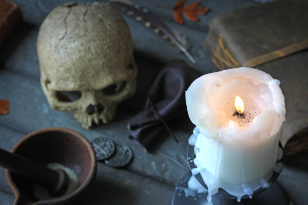 Powerful Voodoo Love Spell. A skull, potion making supplies and spell books.